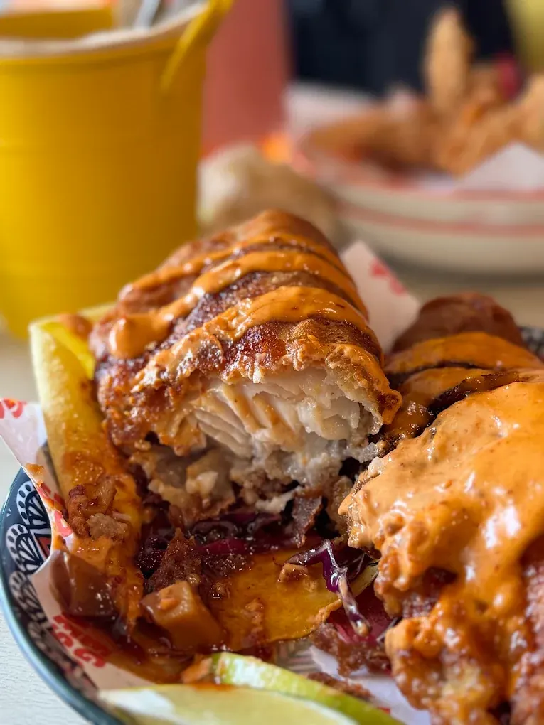 Close-up of a beer-battered fish taco broken open to show the flaky white fish inside the crisp batter