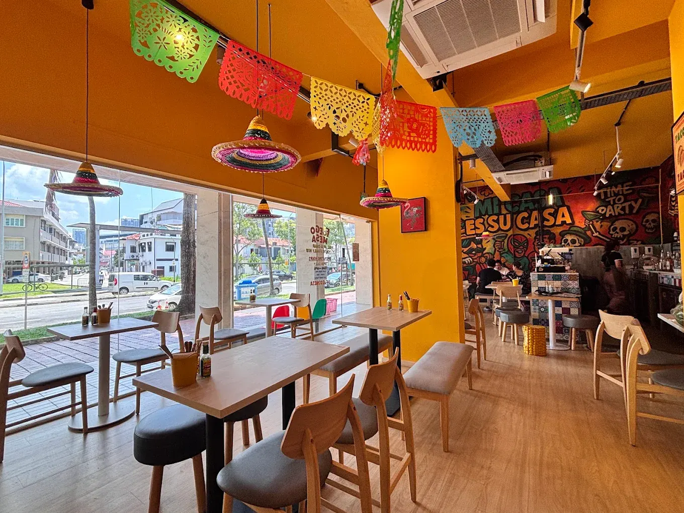 The dining room with papel picado bunting, sombrero lampshades and a window onto Race Course Road