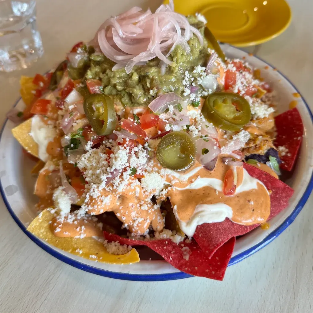 Loaded nachos with guacamole, pickled onions, jalapeños, crumbled cheese and chipotle mayonnaise